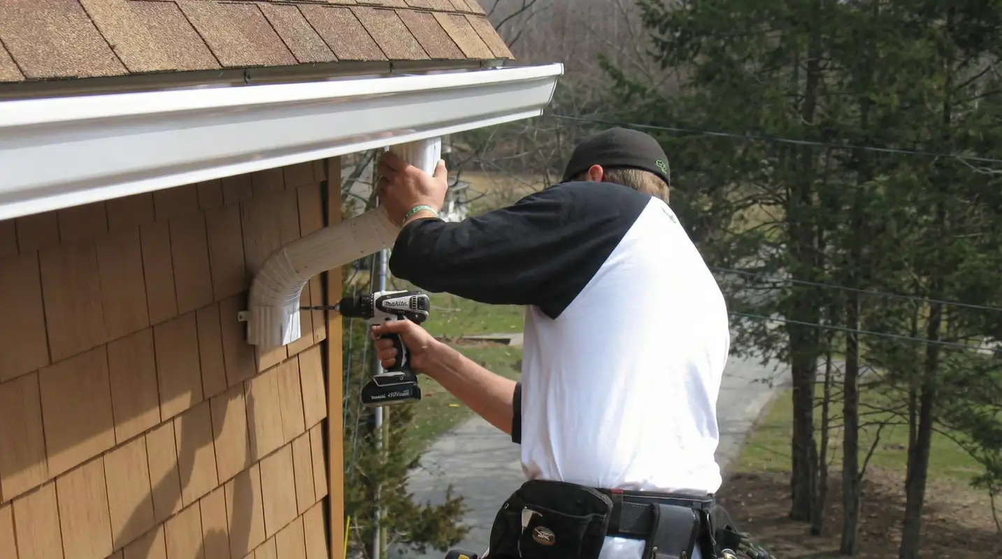 Professional contractor installing tan vinyl siding panels on a residential home exterior in Seattle, WA